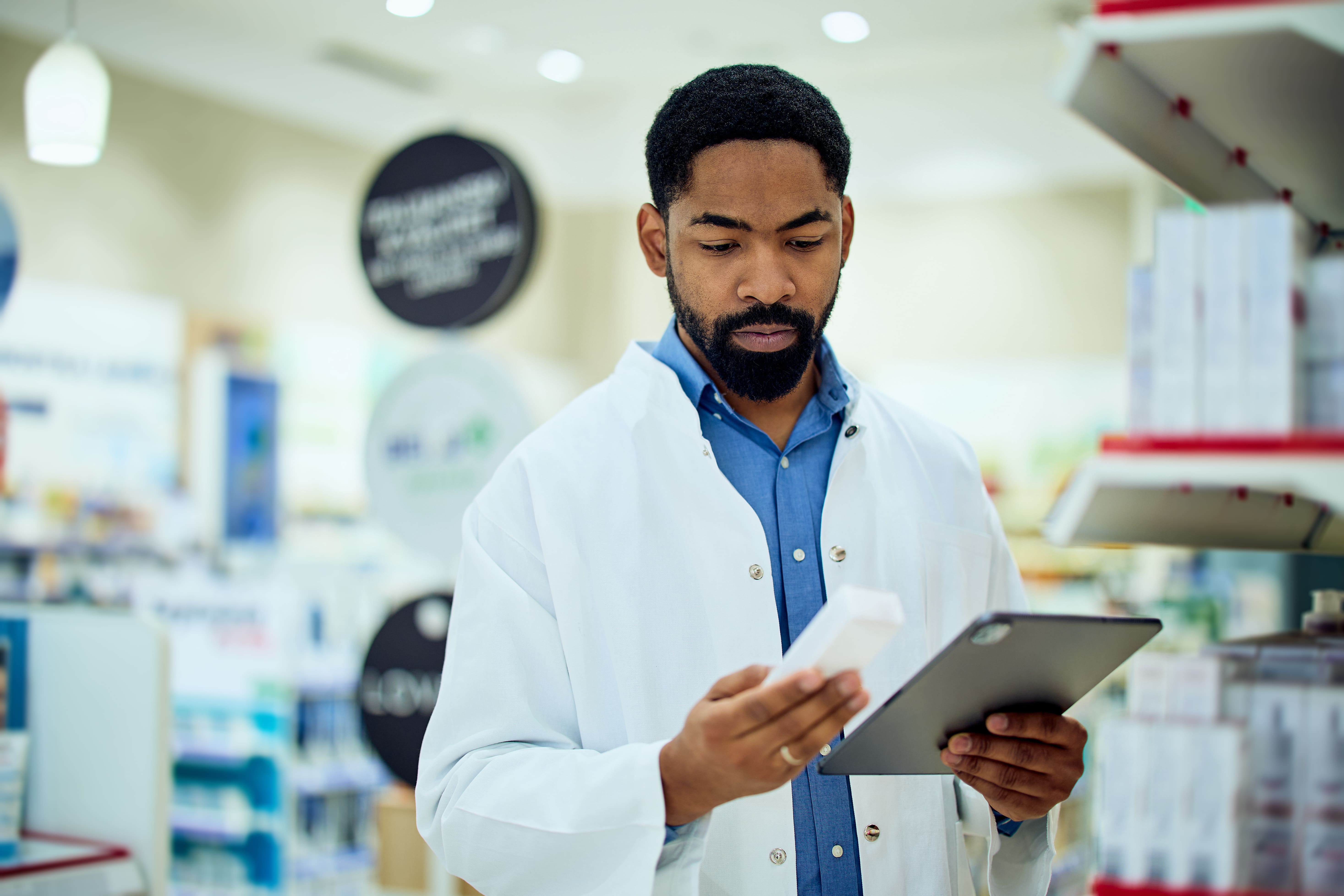 man in lab coat examines medicine box