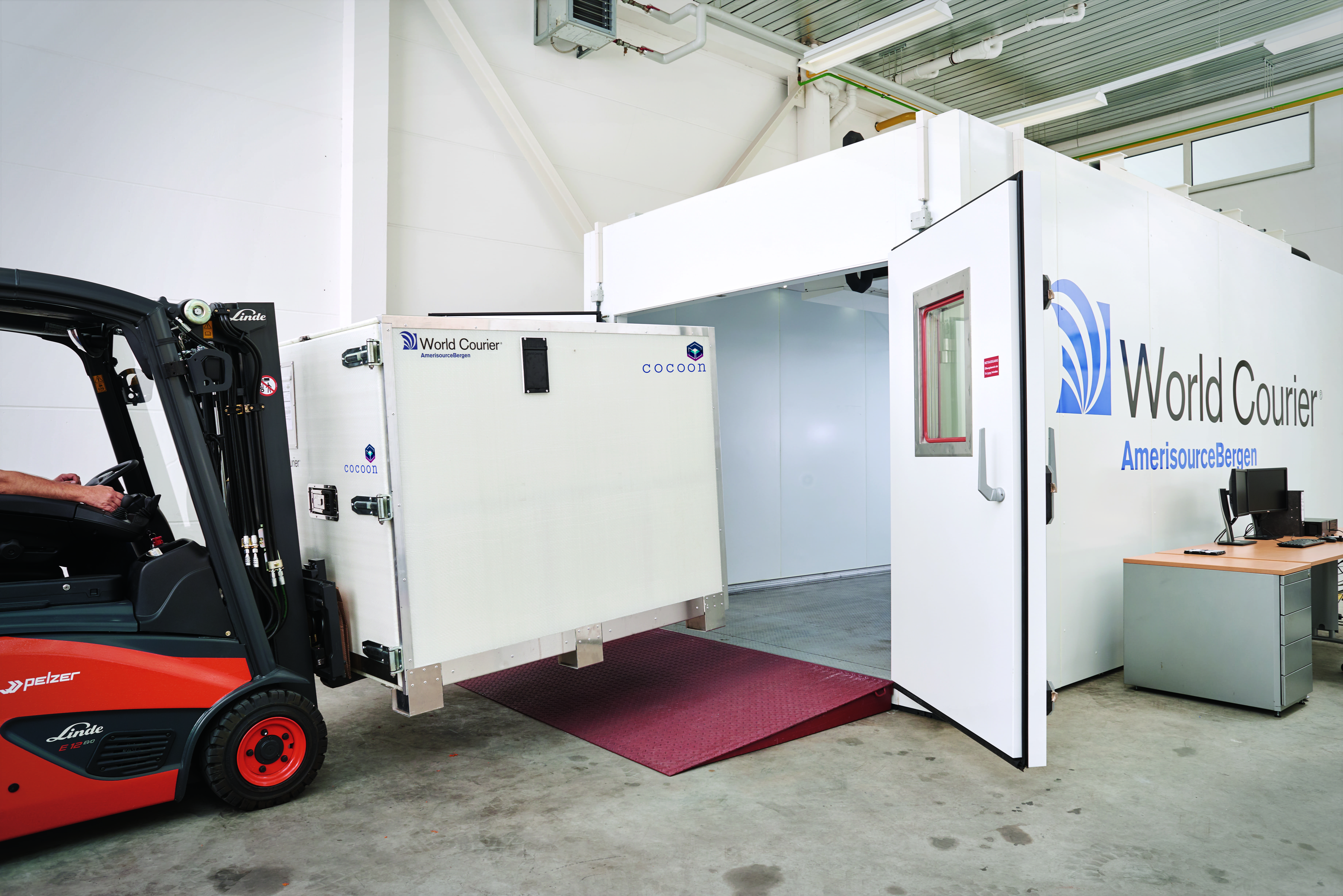 A forklift loads a Cocoon shipping container into a climate chamber at CORE Labs.